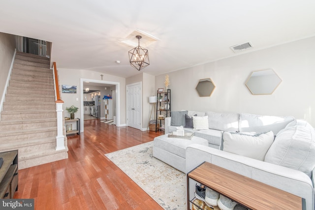 living room featuring wood-type flooring and a notable chandelier