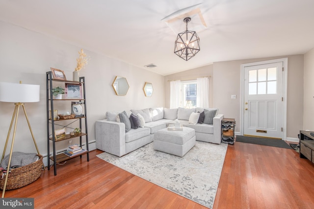 living room featuring hardwood / wood-style flooring, a baseboard radiator, vaulted ceiling, and a notable chandelier