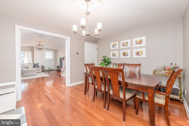 dining area with a notable chandelier and light hardwood / wood-style floors