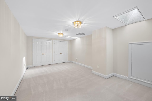 interior space featuring light carpet and two closets