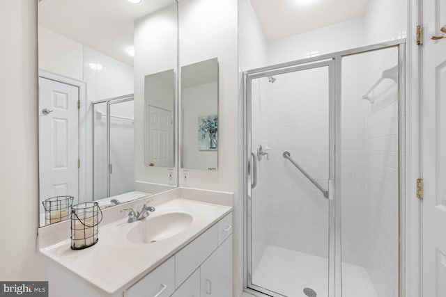 bathroom featuring vanity and a shower with shower door