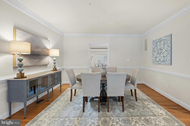 dining space featuring crown molding and hardwood / wood-style floors