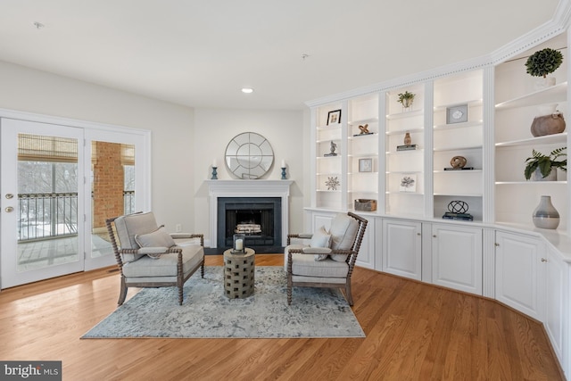 living area featuring built in features and light wood-type flooring