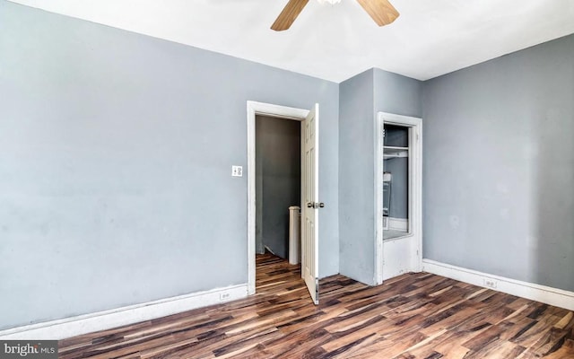 unfurnished bedroom featuring ceiling fan and dark hardwood / wood-style flooring