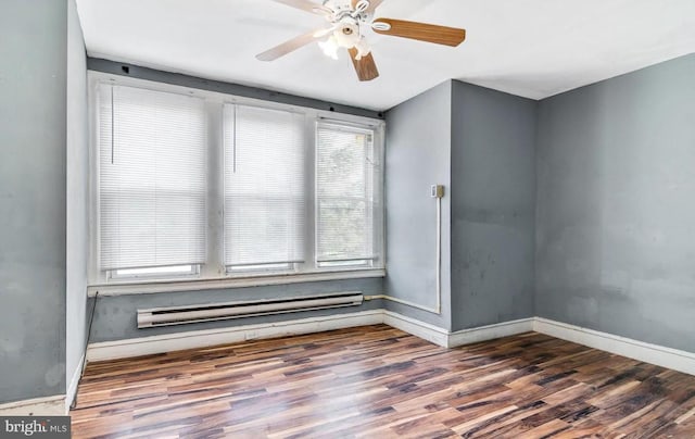 spare room with a baseboard heating unit, dark wood-type flooring, and ceiling fan