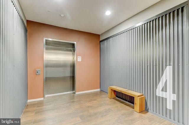 interior space with light wood-type flooring and elevator