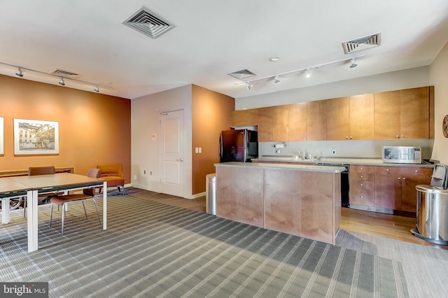 kitchen featuring sink, a kitchen island, and black appliances