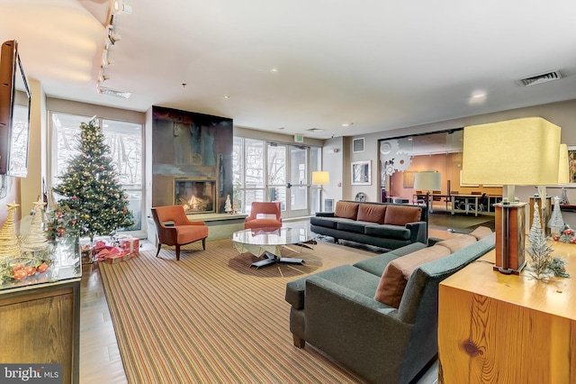 living room with a large fireplace and rail lighting