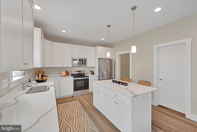 kitchen with light stone countertops, sink, white cabinets, and appliances with stainless steel finishes