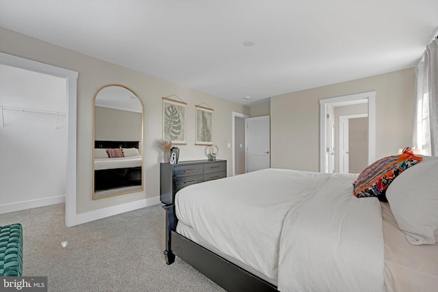 carpeted bedroom featuring a spacious closet and a closet