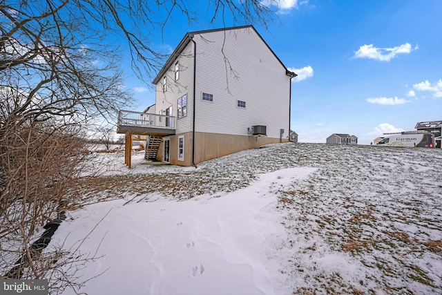 snow covered property featuring a deck and central air condition unit