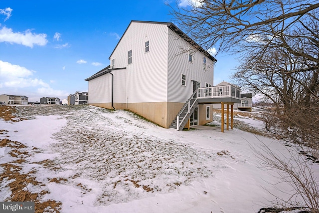 view of snowy exterior with a wooden deck