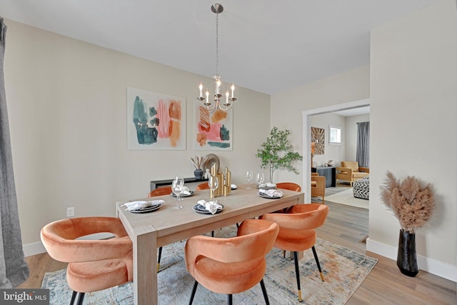 dining space with hardwood / wood-style flooring and a notable chandelier