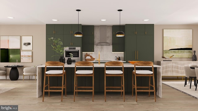 kitchen with hanging light fixtures, wall chimney range hood, a kitchen bar, and modern cabinets