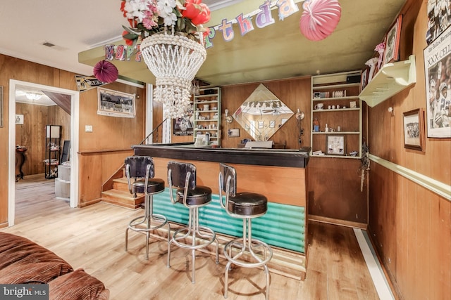 bar with built in features, hardwood / wood-style flooring, and wooden walls