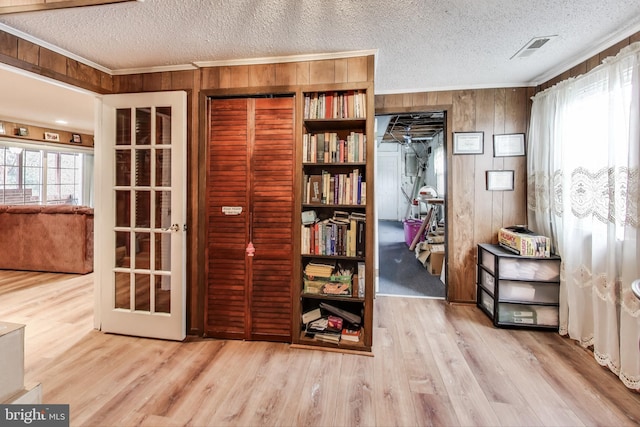 miscellaneous room featuring hardwood / wood-style flooring, a wealth of natural light, a textured ceiling, and wooden walls