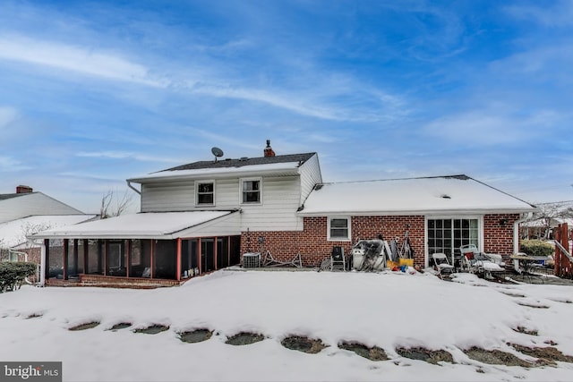 snow covered property featuring a sunroom