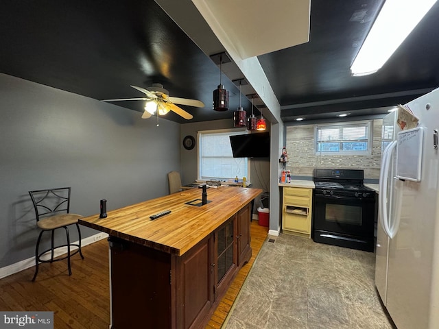 kitchen featuring white refrigerator with ice dispenser, wooden counters, dark brown cabinets, light hardwood / wood-style floors, and gas stove