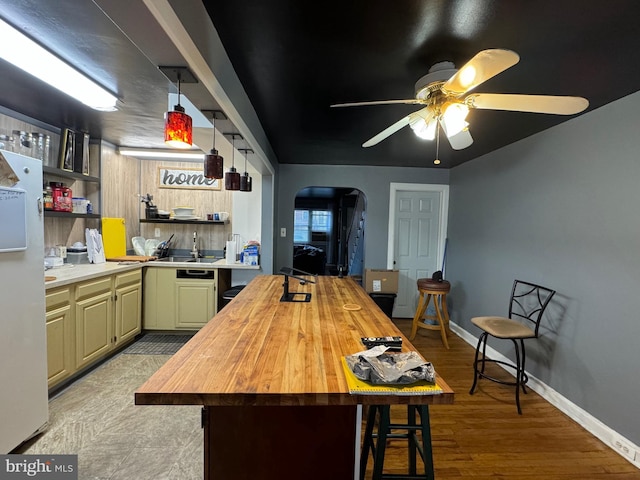 kitchen with ceiling fan, sink, light hardwood / wood-style flooring, white refrigerator, and butcher block countertops