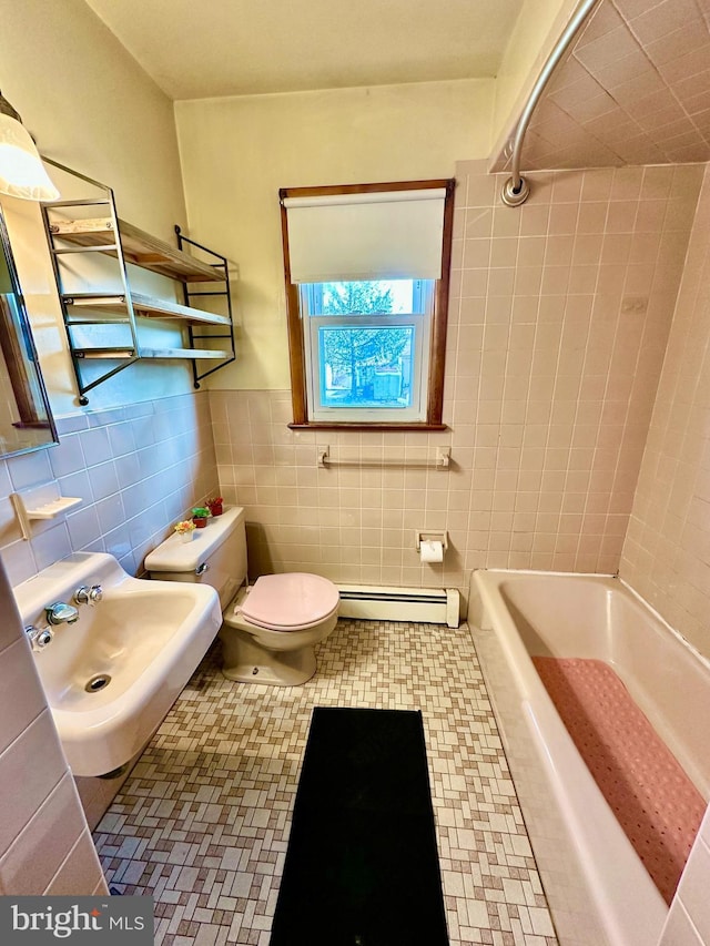 bathroom featuring toilet, sink, tile walls, and a baseboard heating unit