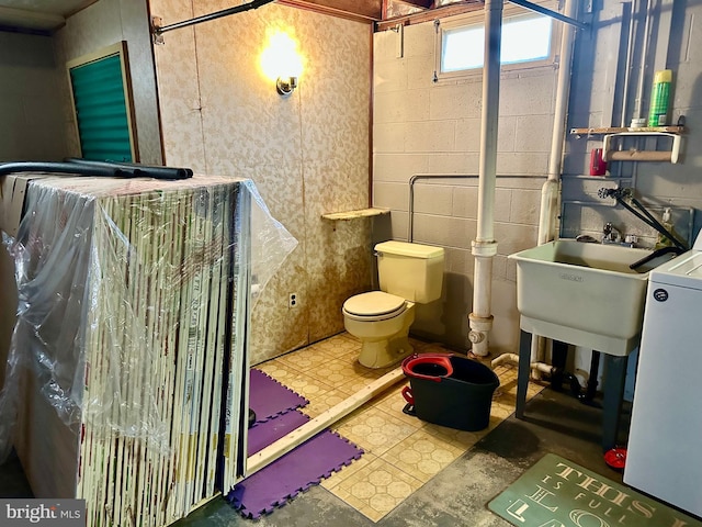 bathroom with toilet, sink, and washer / clothes dryer