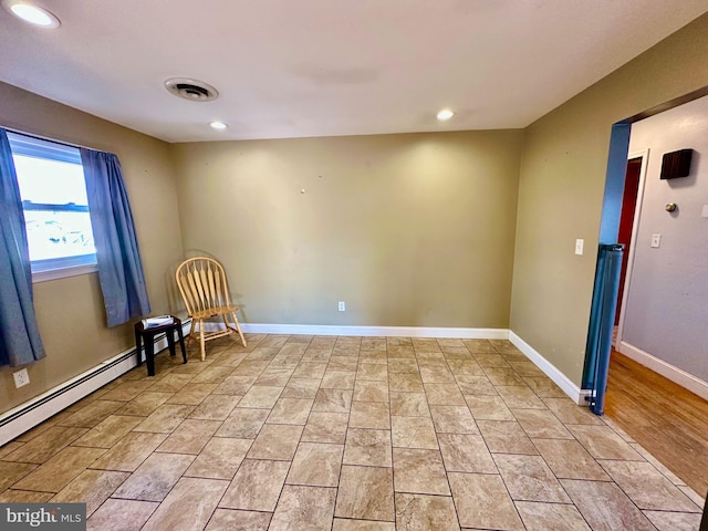 unfurnished room with a baseboard heating unit