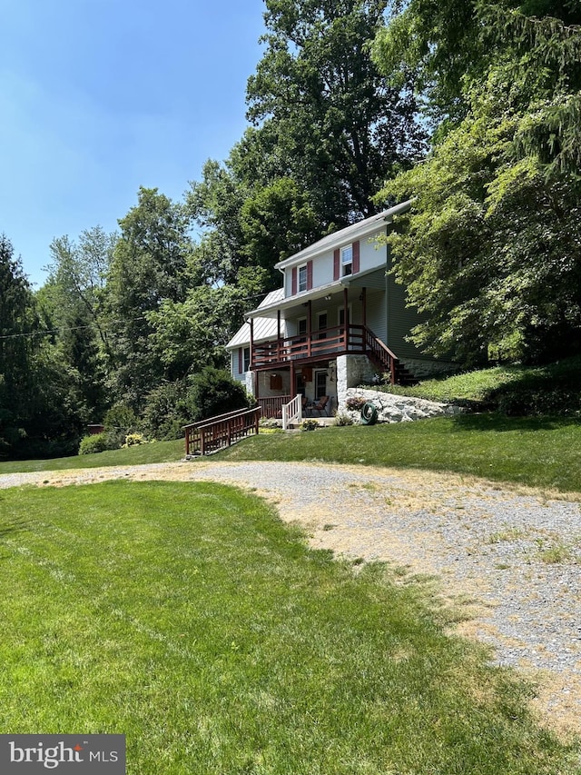 view of front of home with a wooden deck and a front lawn