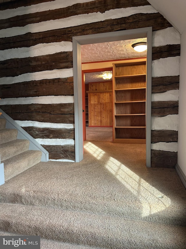 stairway featuring carpet flooring