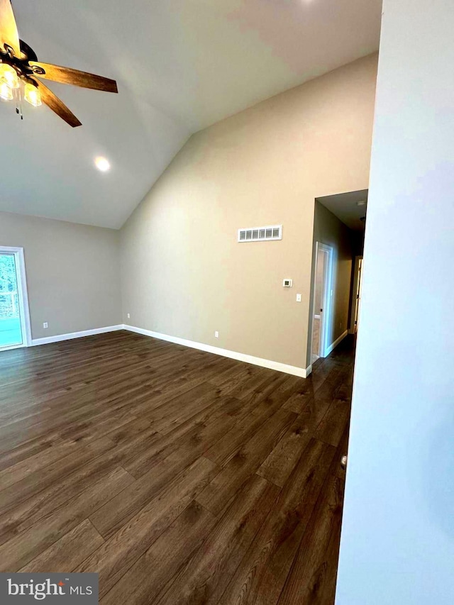 unfurnished living room featuring ceiling fan, vaulted ceiling, and dark wood-type flooring