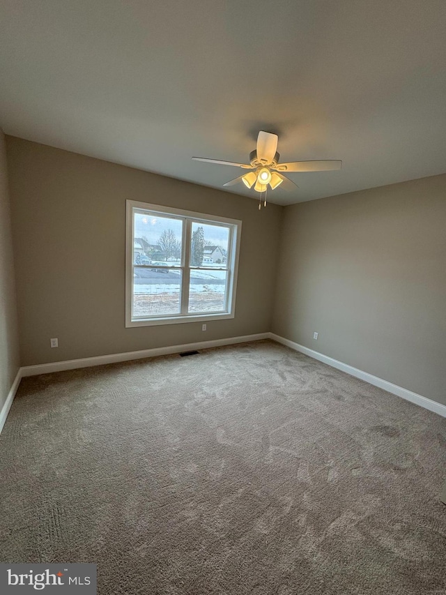 carpeted spare room with ceiling fan