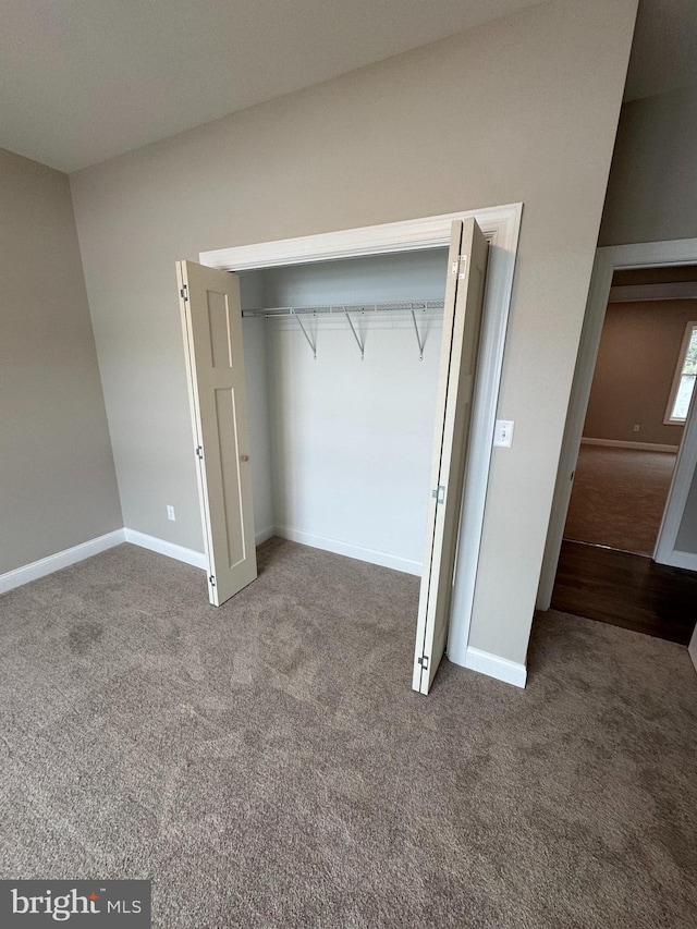 unfurnished bedroom with a closet and carpet flooring