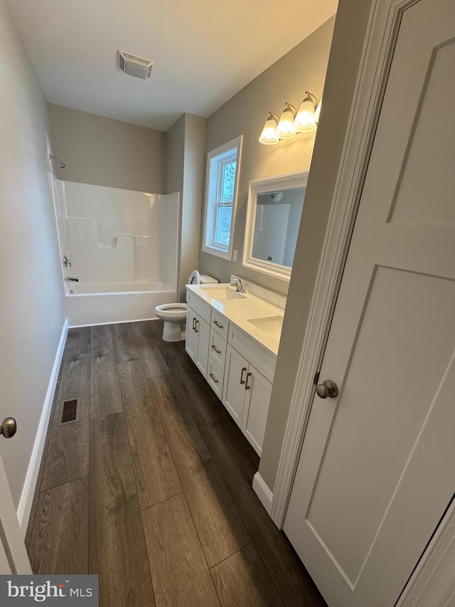 full bathroom with shower / bath combination, wood-type flooring, toilet, and vanity