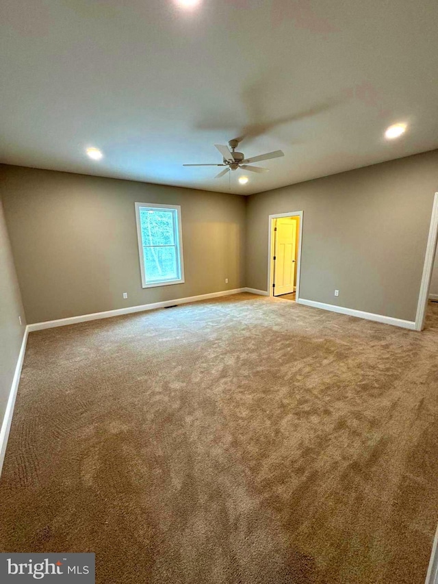 spare room featuring carpet and ceiling fan