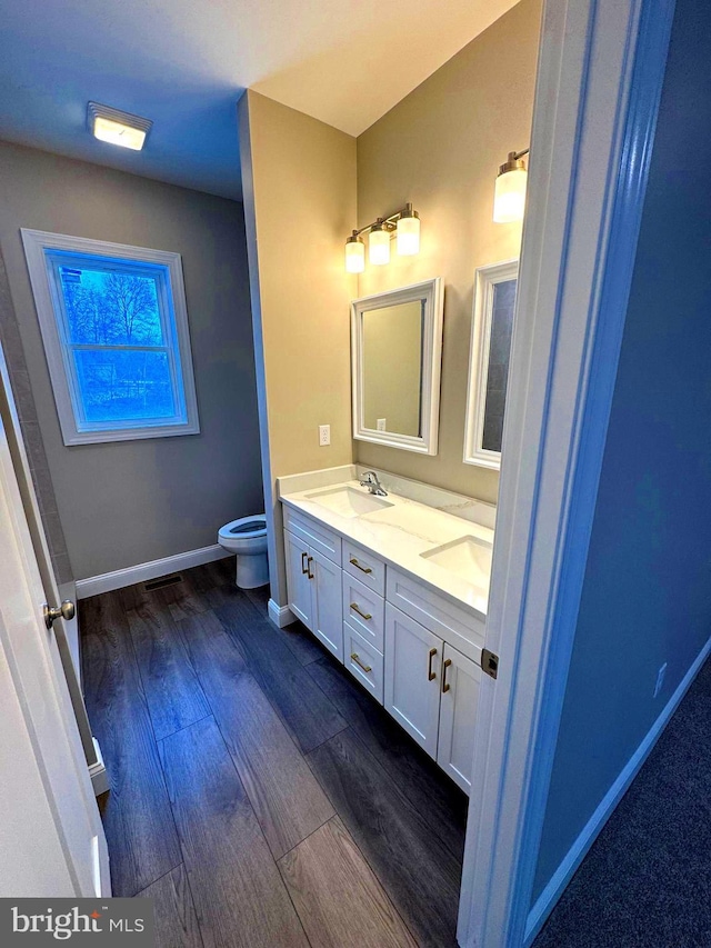 bathroom featuring toilet, hardwood / wood-style floors, and vanity