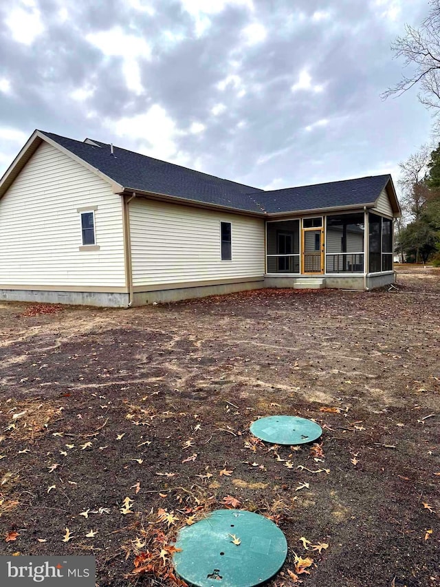 rear view of property featuring a sunroom