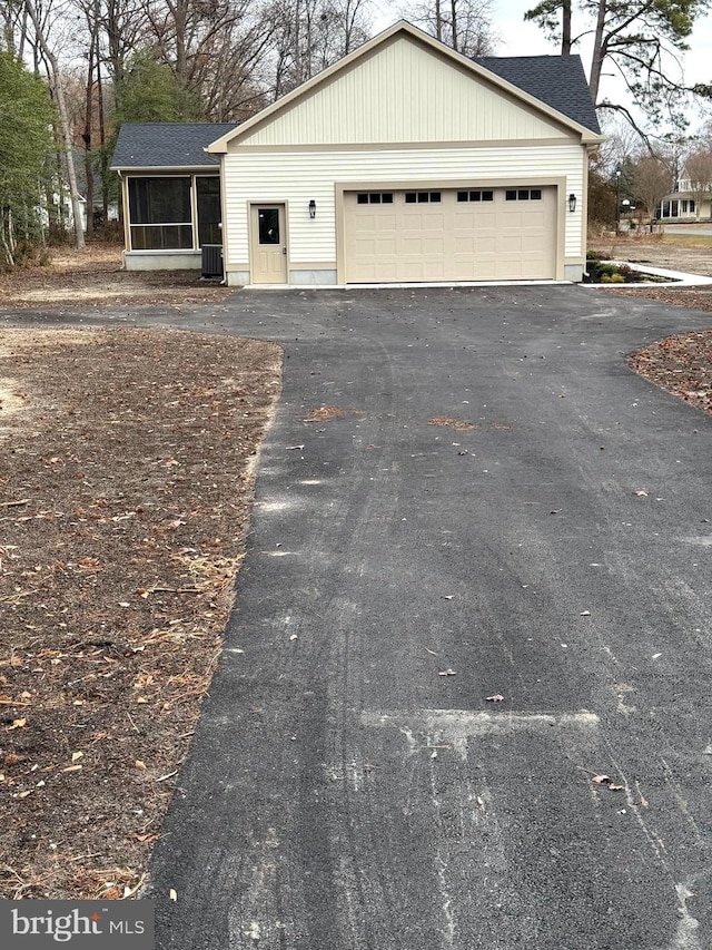 view of front of property featuring central air condition unit and a garage