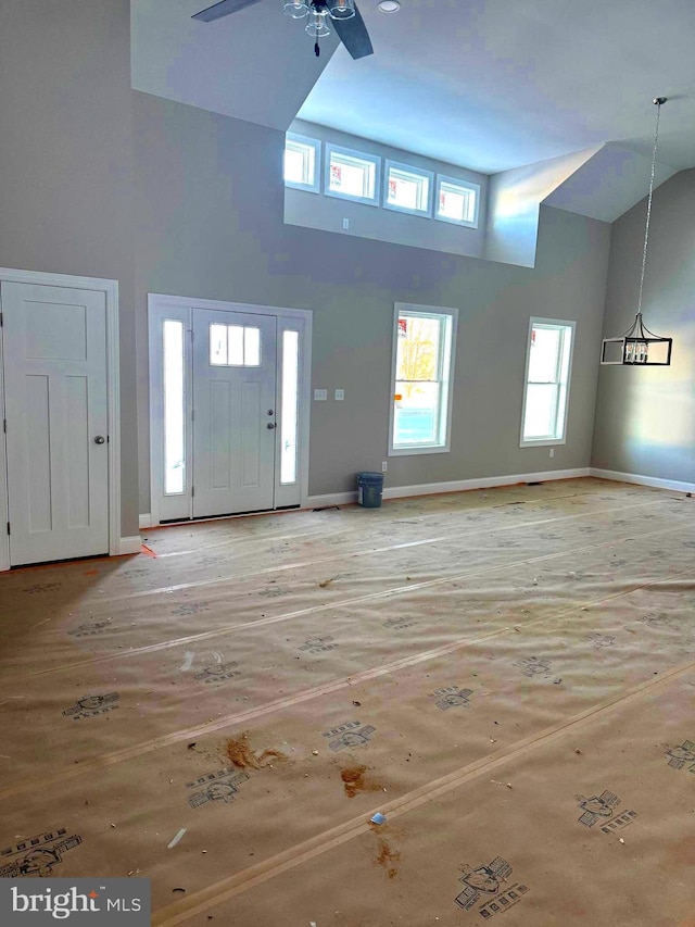 entryway with ceiling fan and a high ceiling