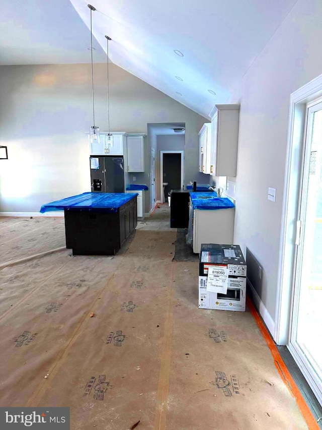 kitchen featuring black refrigerator with ice dispenser, lofted ceiling, a kitchen island, pendant lighting, and white cabinets