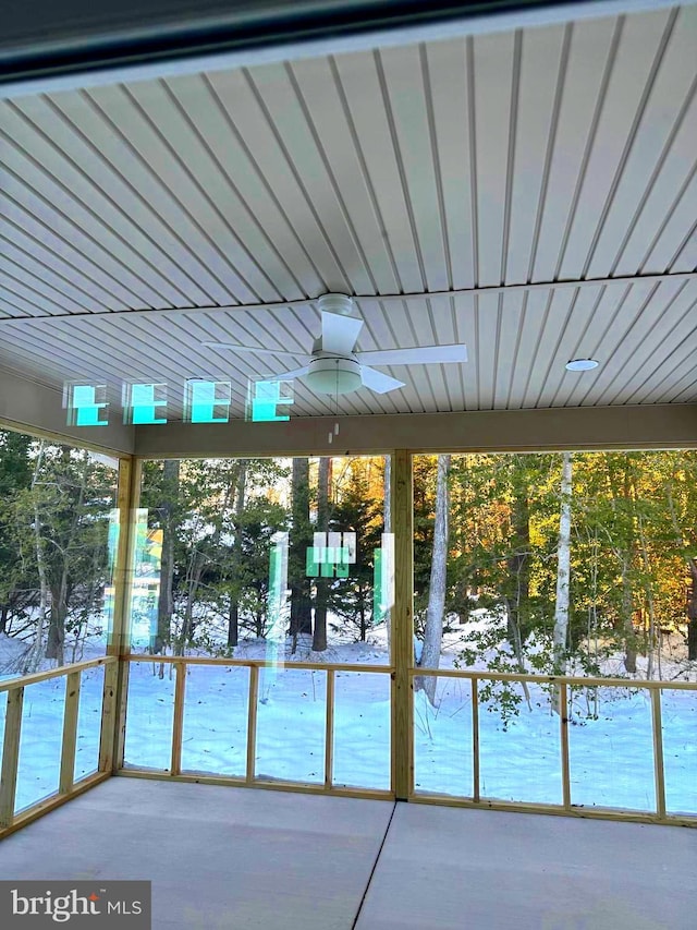 unfurnished sunroom with ceiling fan