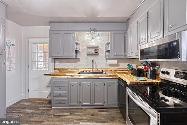 kitchen with gray cabinetry, butcher block counters, sink, and appliances with stainless steel finishes