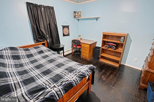 bedroom featuring dark wood-type flooring and a baseboard heating unit