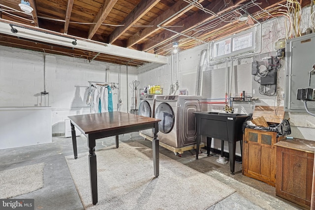 basement featuring washing machine and clothes dryer and electric panel