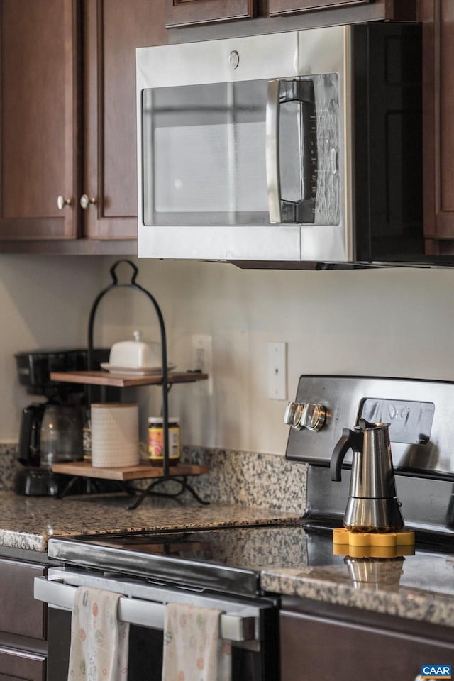 kitchen featuring dark stone countertops and dark brown cabinets