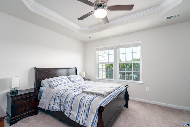 carpeted bedroom featuring a tray ceiling, ceiling fan, and ornamental molding