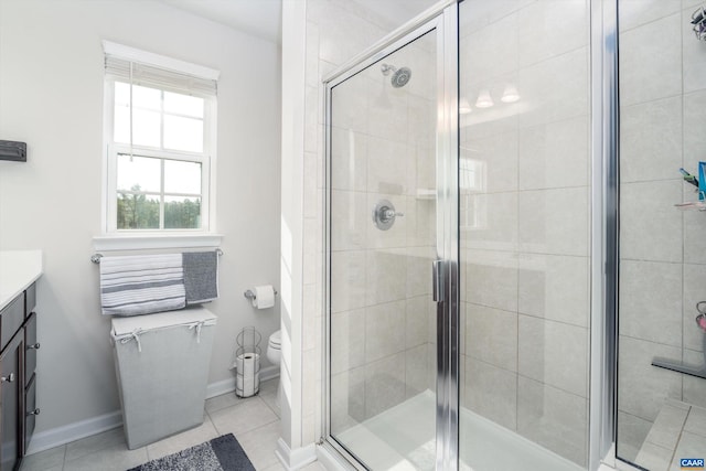 bathroom with tile patterned flooring, vanity, a shower with door, and toilet