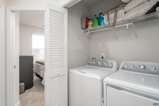 laundry room with separate washer and dryer and light colored carpet