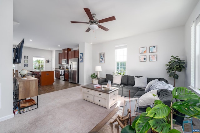 carpeted living room featuring ceiling fan and a healthy amount of sunlight