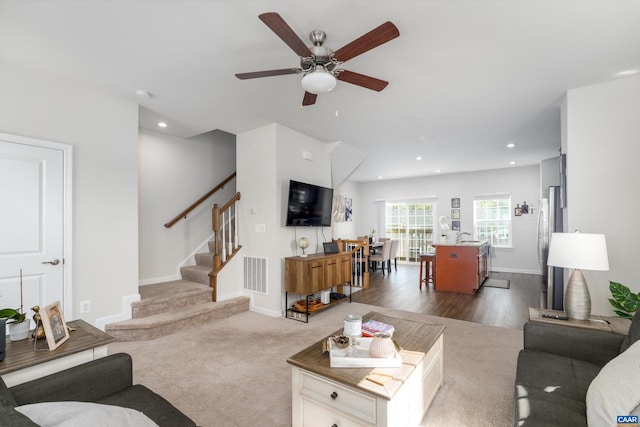 living room with ceiling fan and dark carpet