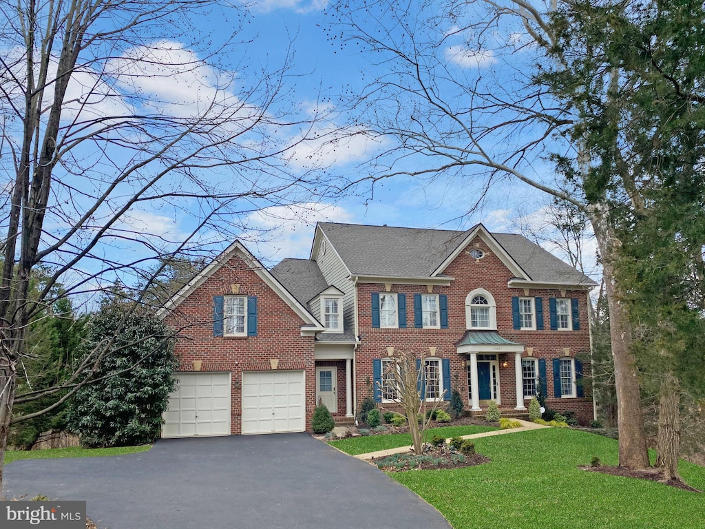 colonial house featuring a garage and a front yard