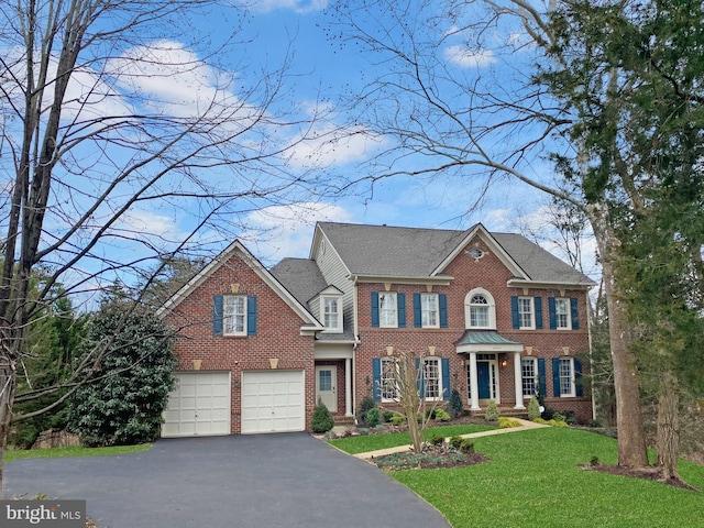 colonial house with a front yard and a garage